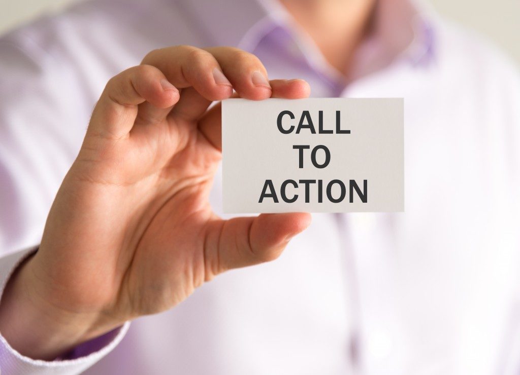Closeup on businessman holding a card with CTA CALL TO ACTION message