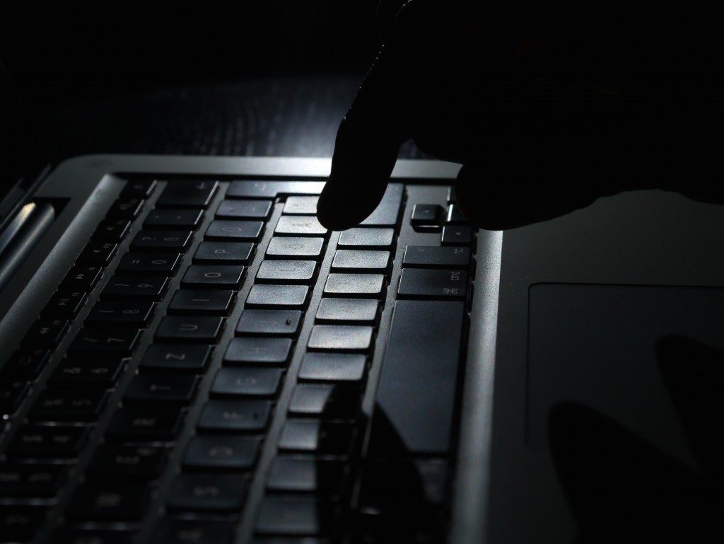 Cybercrime - one finger shadow on keyboard