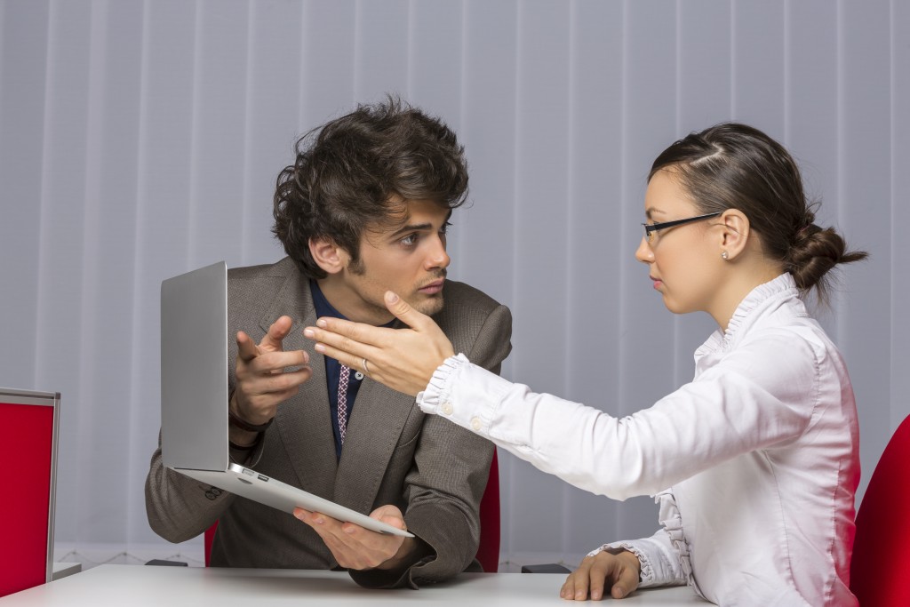 Man showing laptop to female