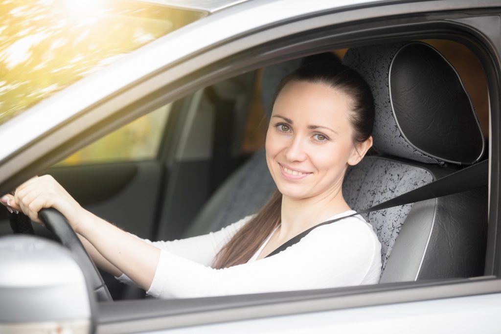 Portrait of smiling lady driver showing thumb up