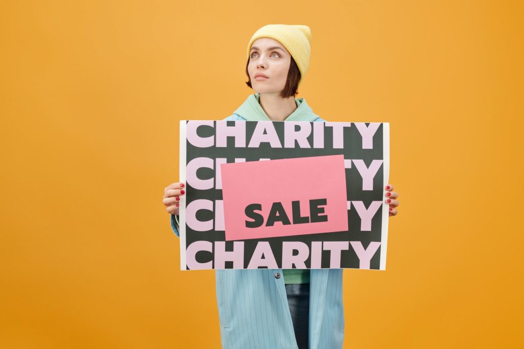 woman holding sign charity sale
