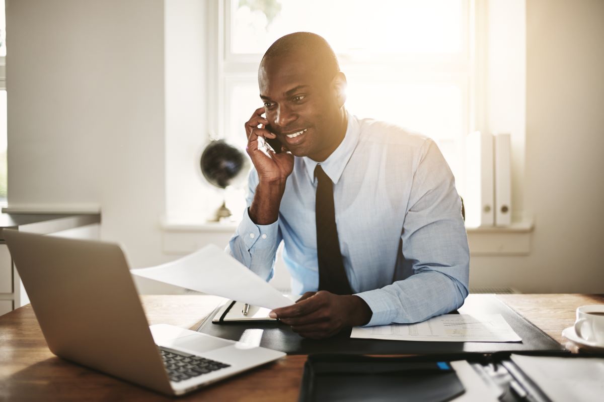 man talking on the phone looking at laptop